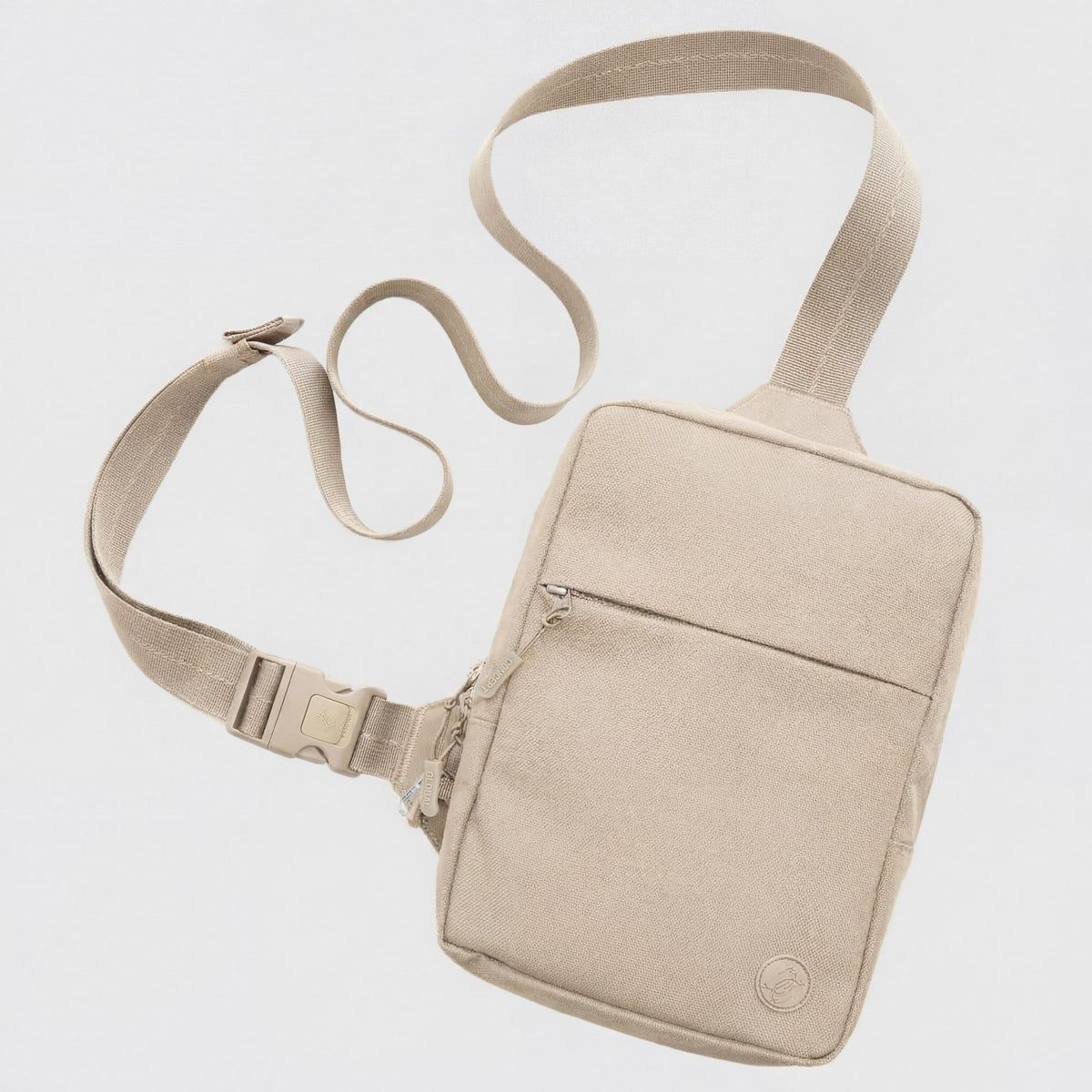 Beige crossbody bag with a strap on a light gray background